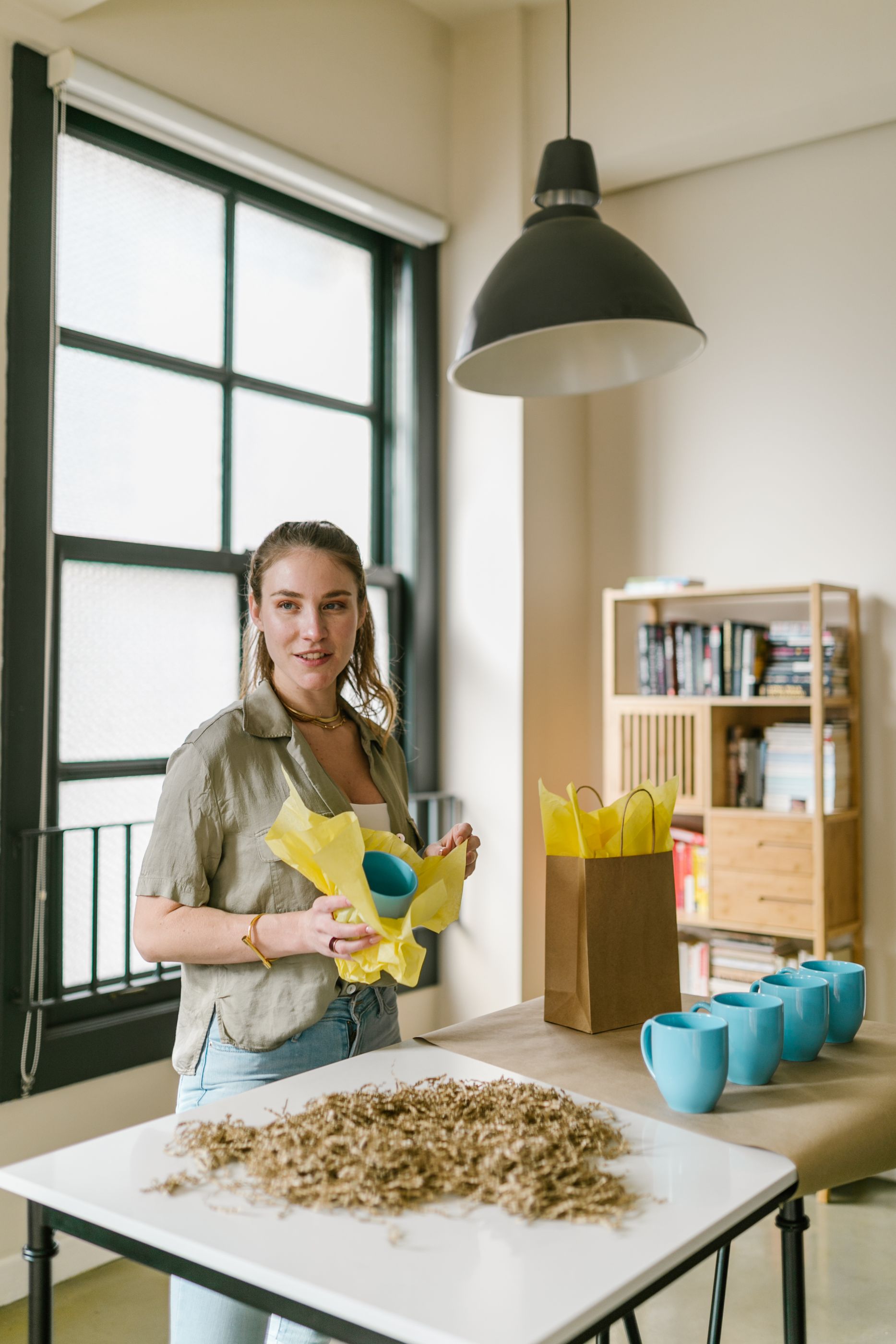 A small business owner preparing branded packaging at a worktable